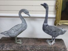 A pair of cast metal garden ornaments modelled as geese, larger height 71cm