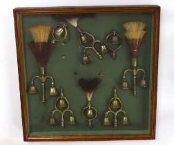 A collection of Victorian horse brass bell terrets, housed in a display case, 46cm high