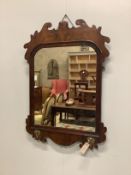 A George II walnut fret cut wall mirror, with candle arm brackets, width 58cm, height 84cm