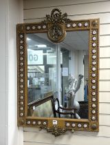 A Louis XVI style ormolu mounted wall mirror applied with porcelain plaques printed with flowers,