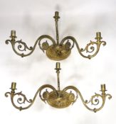 A pair of ornate brass three branch wall lights, 41cm wide