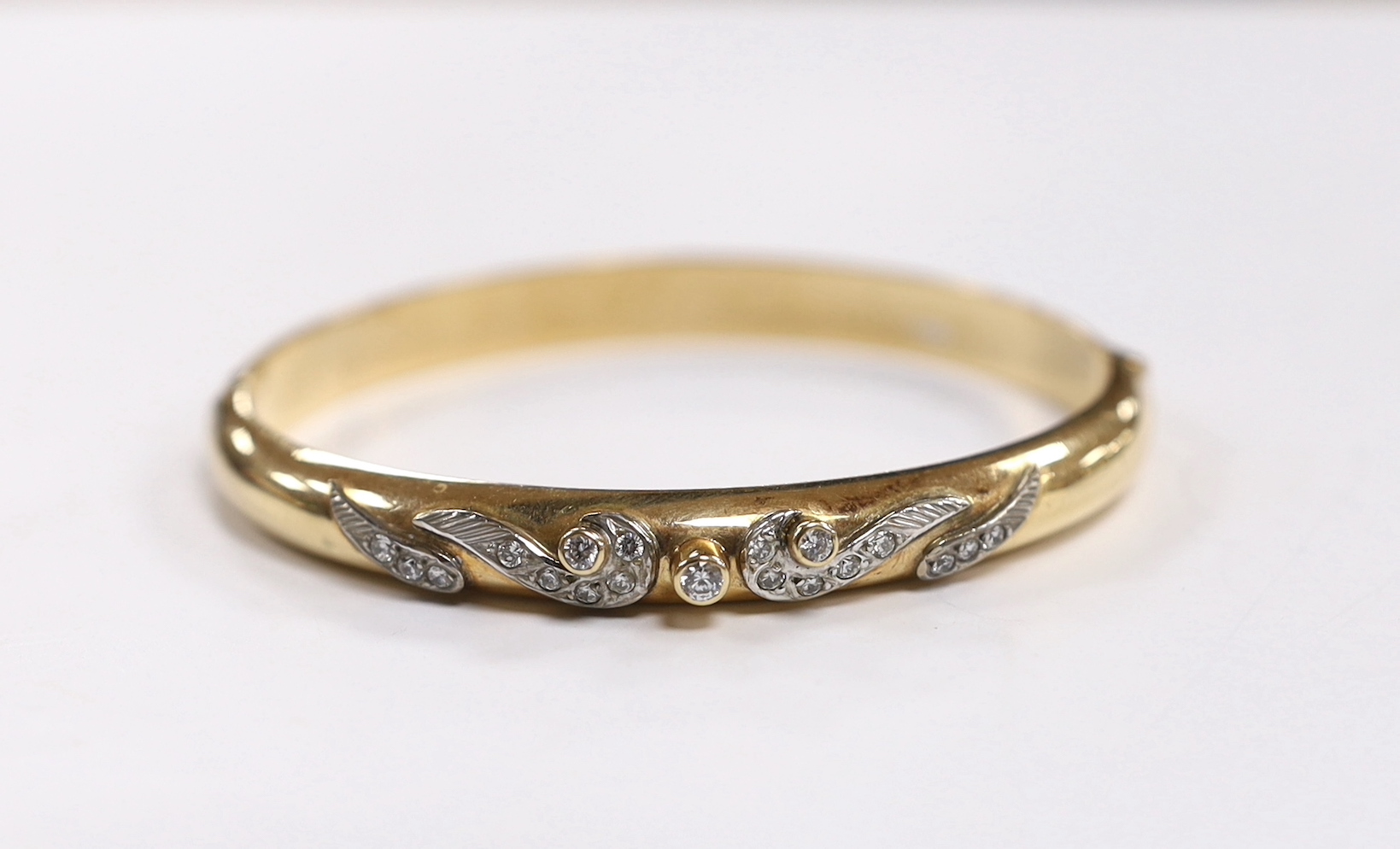 A 585 yellow metal and simulated diamond set hinged bangle, gross weight 20 grams.