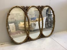 A Victorian style gilt composition triple oval overmantel mirror, width 160cm, height 110cm