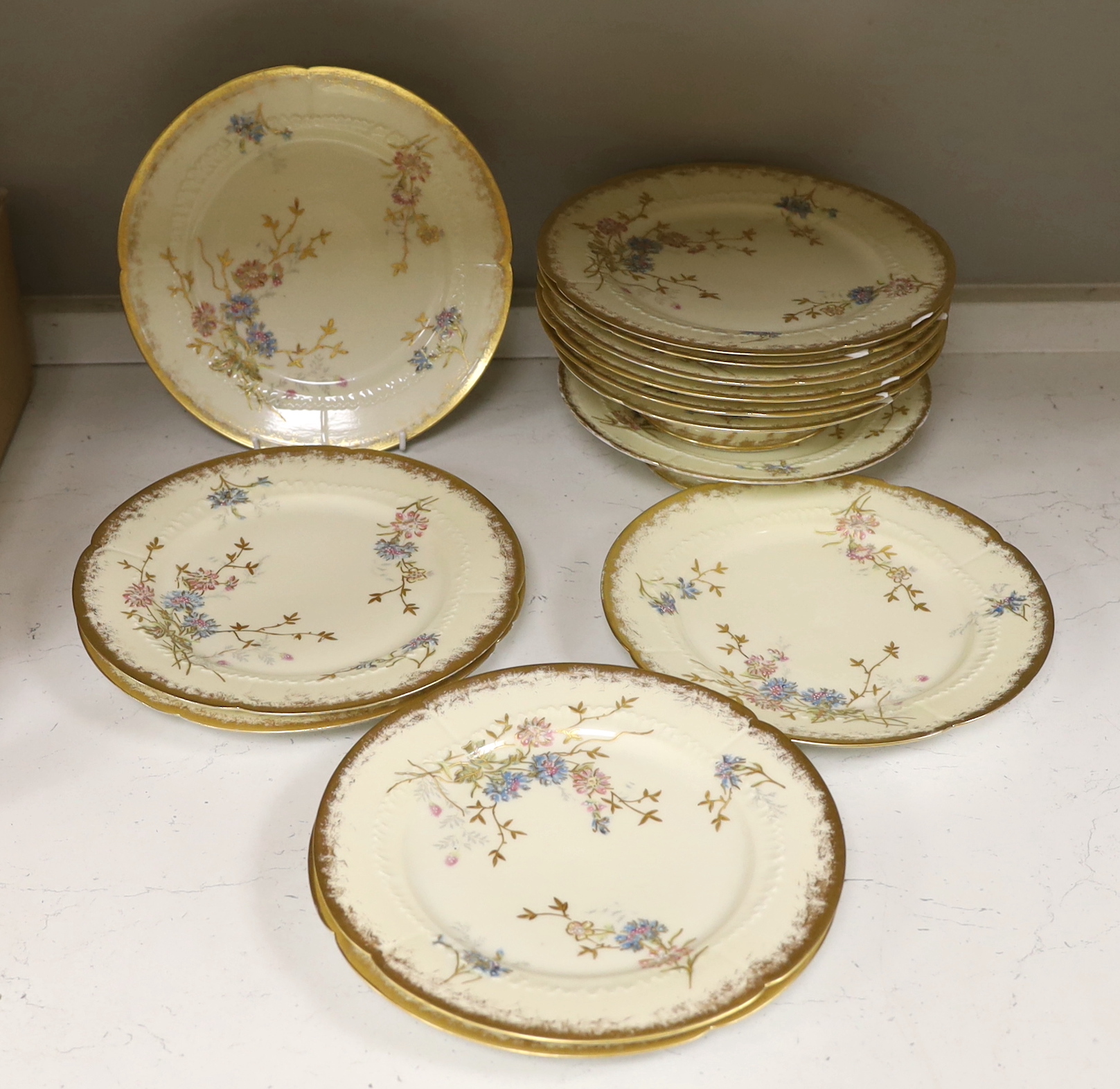Thirteen Limoges style porcelain dessert plates, two on pedestal bases, gilt decorated with