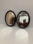 A pair of modern oval mahogany bevelled wall mirrors, width 59cm, height 77cm