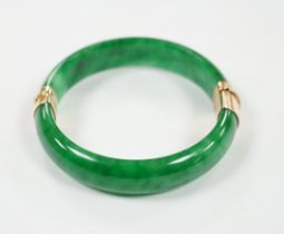 A yellow metal mounted jadeite hinged bangle, interior diameter 58mm, gross weight 59 grams.