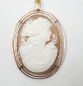 An early 20th century 9ct mounted oval cameo shell pendant, carved with the bust of a lady to
