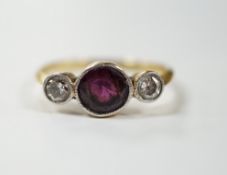 An early 20th century yellow metal and millegrain set single stone garnet and two stone diamond