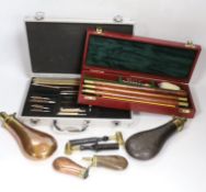 Three copper powder flasks, a leather powder flask, two powder measures and two cases of cleaning