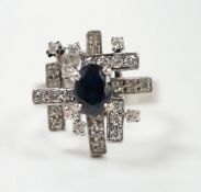 A modern 18k white metal, sapphire and diamond set modernist ring, size K/L, gross weight 6.1