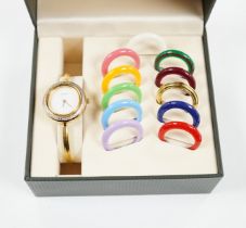 A lady's modern gilt Gucci quartz bangle wrist watch, with twelve interchangeable bezels, in