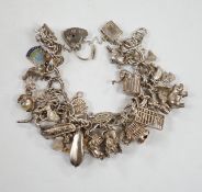 A 1970's silver charm bracelet, hung with assorted charms including birdcage, abacus, piglet, etc.