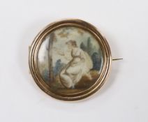 A 19th century yellow metal mounted circular brooch, with glazed back and inset miniature