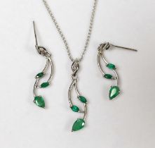 A modern white metal, three stone emerald and single stone diamond set pendant 31mm, on an 18ct fine