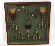 A collection of Victorian horse brass bell terrets, housed in a display case, 46cm high