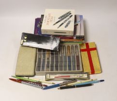 A collection of pens including Parker and pen-related publications