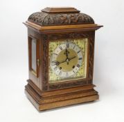 A carved walnut mantel clock with German movement, 36cm