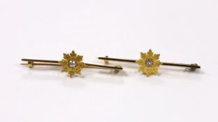 A pair of early 20th century yellow metal and single stone diamond set flower head bar brooches,
