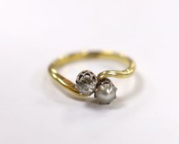 An 18ct, single stone diamond and single stone cultured pearl set crossover ring, size L/M, gross