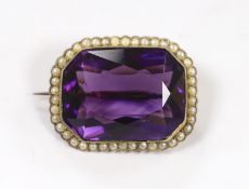 An Edwardian yellow metal mounted emerald cut amethyst and seed pearl cluster set brooch, 31mm,