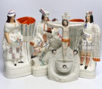 Four Staffordshire figure groups; a Crucifixion stoup, a pair of vases, a Scottish group and two