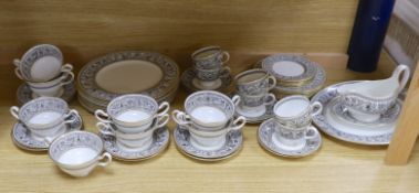 A Wedgwood Florentine part dinner set including twin handled cups, oval platter and dinner plates,