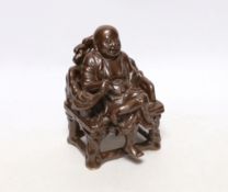 A late 19th/ early 20th century Chinese porcelain faux bronze figure of Budai seated on a throne,