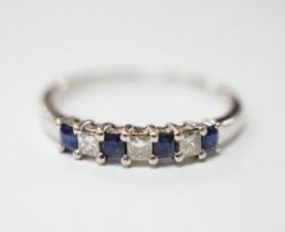 A modern 18k and plat, sapphire and diamond set seven stone half hoop ring, size O, gross weight 1.8