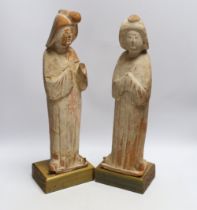 A pair of Chinese painted terracotta figures, possibly Tang Dynasty, on stained pine bases, 42cm