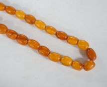 A single strand, barrel and oval amber bead necklace, 108cm, gross weight 76 grams.