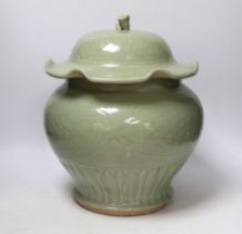 A large Chinese celadon jar and cover, Ming dynasty or later, the lotus leaf shaped cover above a