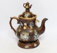 A Measham Barge ware glazed pottery teapot, decorated in relief, 28cm wide