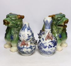 Two Chinese blue and white with iron red ‘dragon’ vases and a near pair of lion dogs, tallest 26cm