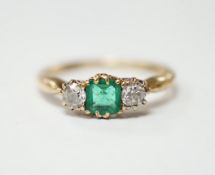 An early to mid 20th century 18ct, emerald and diamond set three stone ring, size O/P, gross