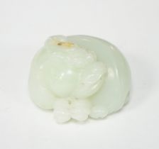 A Chinese celadon jade carving of a lion-dog, in recumbent pose, its crest with a russet