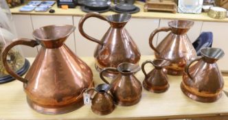 A composed set of seven Victorian copper graduated haystack measures, tallest 41cm