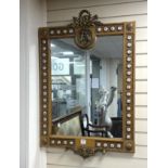 A Louis XVI style ormolu mounted wall mirror applied with porcelain plaques printed with flowers,