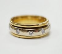 A modern 750 yellow metal ring, with central diamond set rotating white metal band (stone