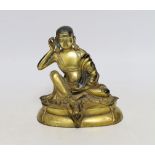 A Sino-Tibetan gilt bronze seated figure of Milarepa, 14cm high