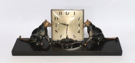 A patinated spelter Art Deco clock surmounted with two panthers, 40cm high