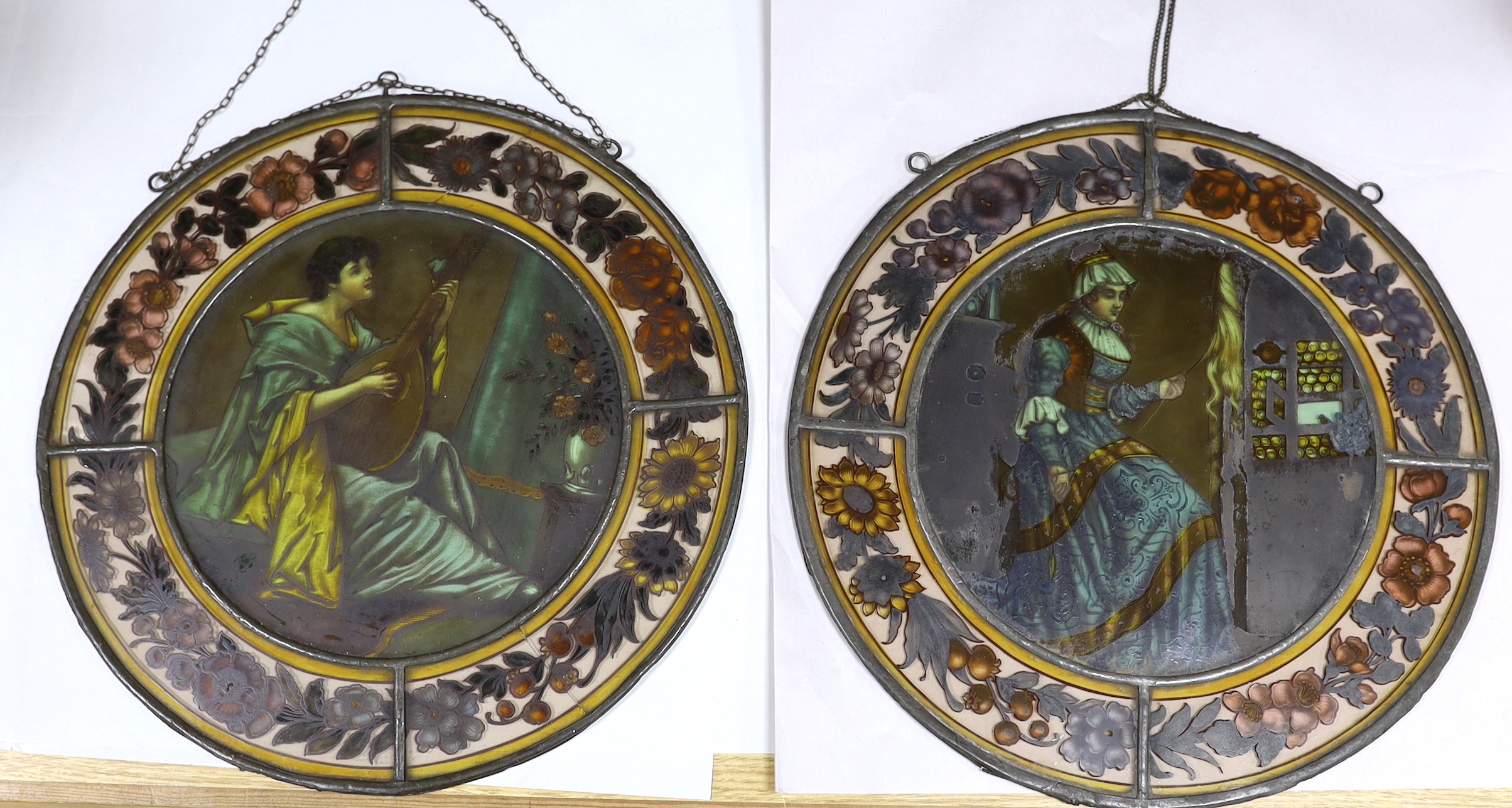 Two Victorian stained glass leaded roundels, one depicting a gentleman playing a lute, 32cm in