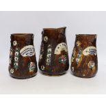 Three Measham barge ware glazed pottery jugs, decorated in relief, largest 22cm high