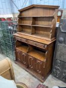 An Arts and Crafts pine buffet with arched top, width 150cm, depth 46cm, height 205cm