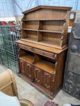 An Arts and Crafts pine buffet with arched top, width 150cm, depth 46cm, height 205cm