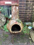 An earthenware chiminea on wrought iron stand, height 96cm