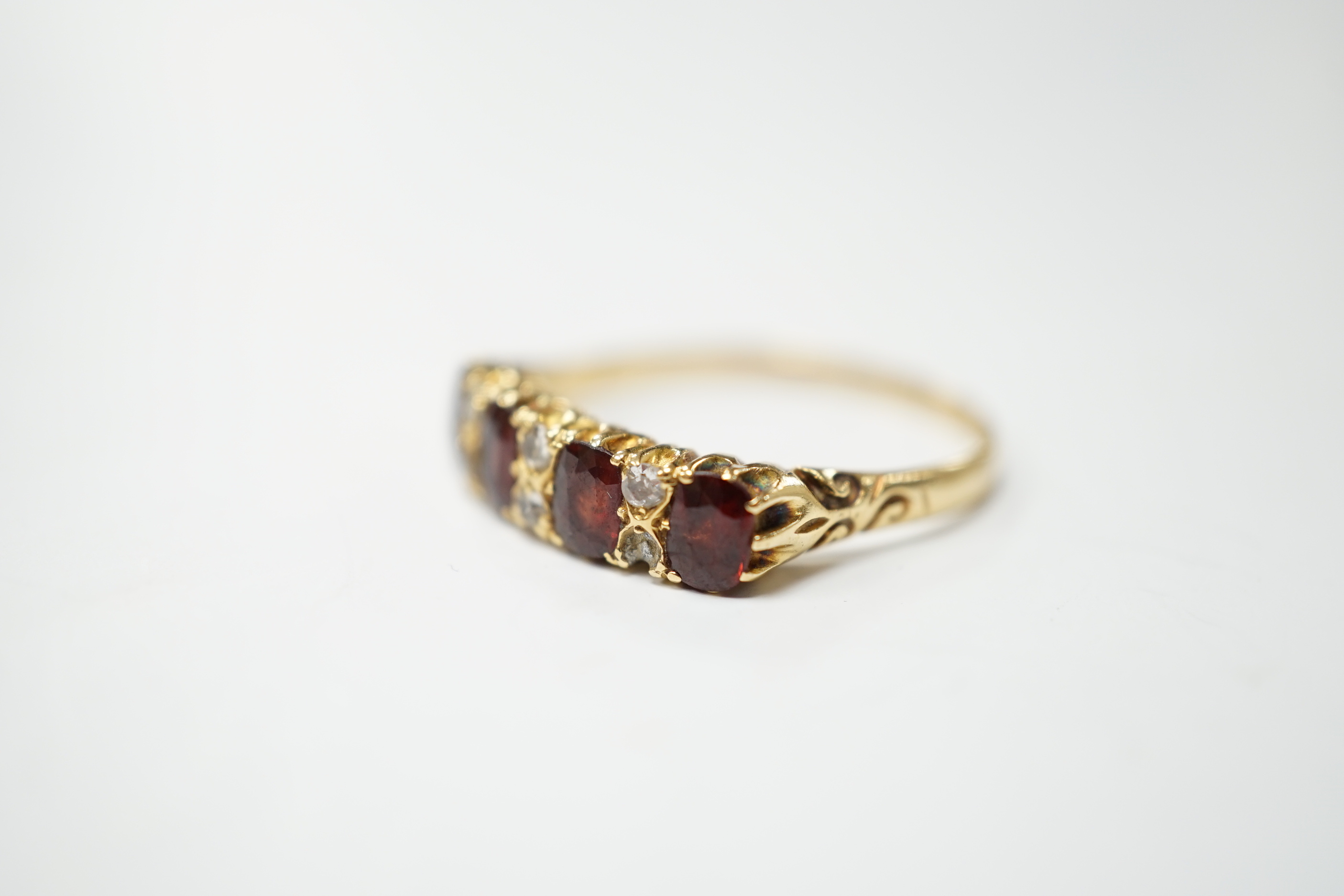 An Edwardian 18ct gold and four stone garnet set half hoop ring, with diamond chip spacers, size - Image 3 of 4