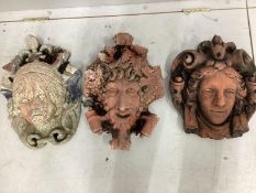 Three terracotta garden mask wall appliques, largest height 43cm