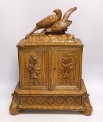 A late 19th century Black Forest carved wooden two door table top cabinet, interior with fitted