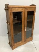A Cotswold style glazed oak two door bookcase, width 90cm, depth 27cm, height 130cm