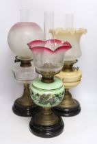 Three glass and brass oil lamps, c.1900, tallest 57cm